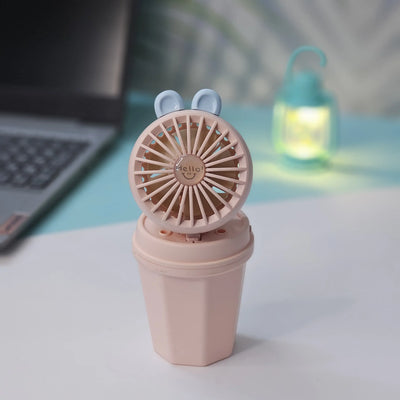 Front view of two Usmile Toys Hi Speed Kids Desk Fans, a blue and a pink one, showing their round grilles with a 'hello' emoji and charming bunny ears, suitable for adding a breeze and fun to any desk."