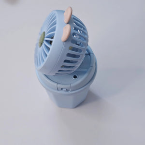 Front view of two Usmile Toys Hi Speed Kids Desk Fans, a blue and a pink one, showing their round grilles with a 'hello' emoji and charming bunny ears, suitable for adding a breeze and fun to any desk."