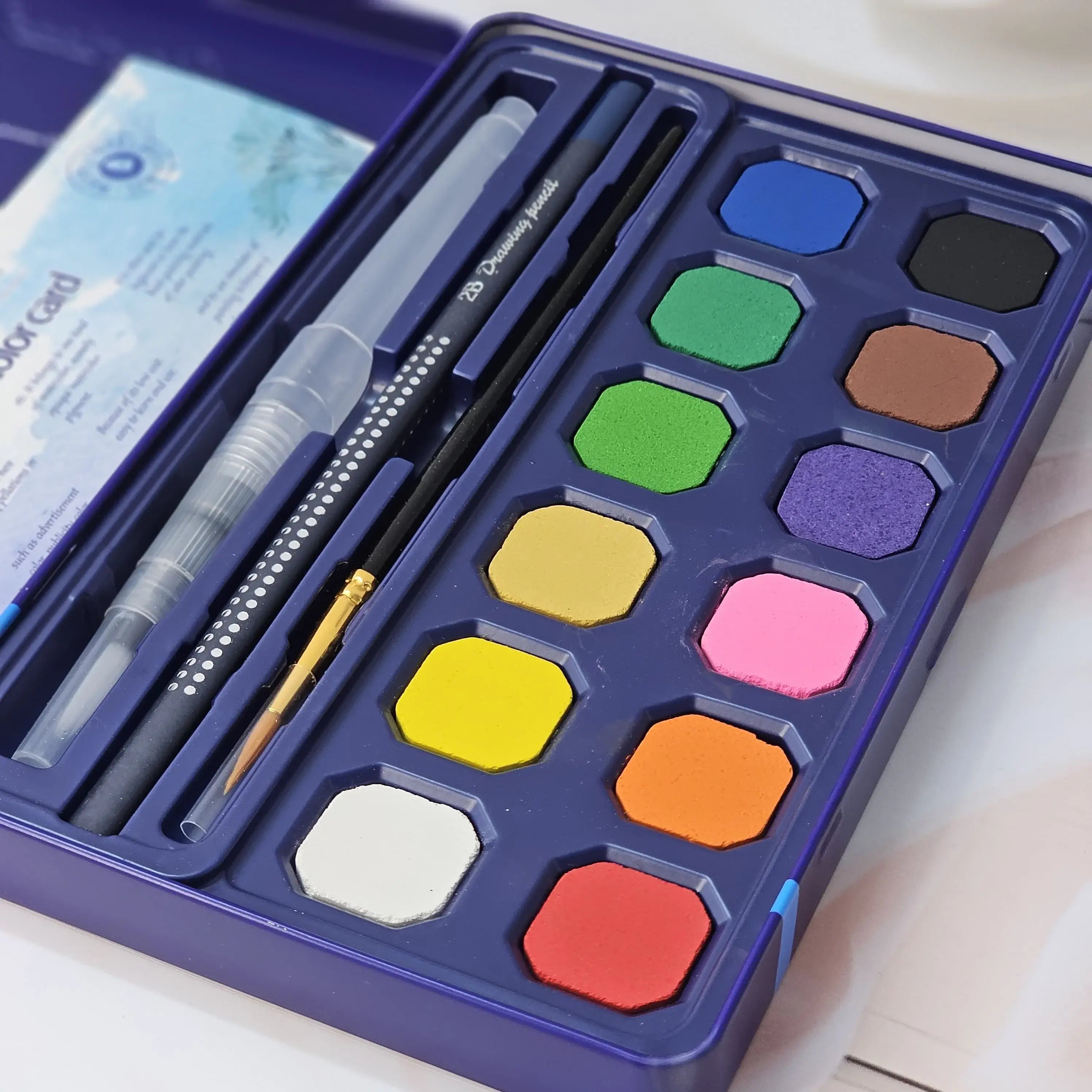 Usmile Toys art supplies: a 'Compulsory Course' 12-color solid watercolor cake set, complete with water brush and sponge, as shown on its packaging." www.usmile.toys