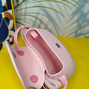 Pink and white dog muzzle on a yellow surface with a colorful abstract pattern in the background