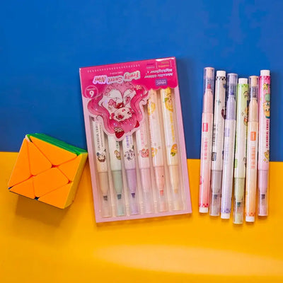 Set of 6 colorful metallic glitter highlighter pens for kids, packaged in two pastel-themed boxes labeled “Fruity Sweet Mix.” Each pen features cute cartoon character prints and soft, vibrant ink colors perfect for journaling, school projects, or creative doodling. The packaging is designed with anime-style illustrations of girls in whimsical outfits, appealing to children and stationery lovers. Displayed on a dual-tone yellow and blue background, this pen set makes a fun and eye-catching gift for birthdays