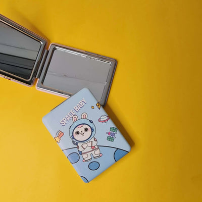 Compact mirror with cartoon design on a yellow background