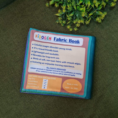 A "My Amazing Body: Head to Toe" fabric book by Kidogen, showing a cartoon child meditating with illustrations of body parts and organs around them.