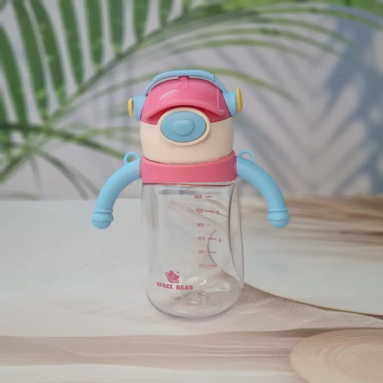 Set of three Space Bear plastic water bottles for kids in blue, red, and pink, each with a straw, handle, and unique bear-themed cap resembling headphones. Ideal sippy cups for toddlers and school children on usmile.toys. www.usmile.toys