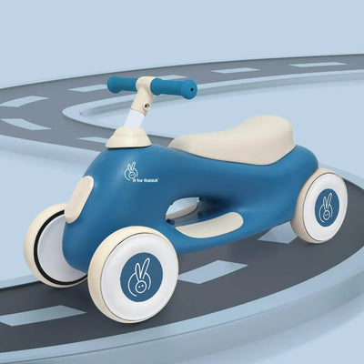 Blue and beige children's balance bike on a road-like surface with a light blue background