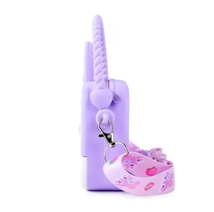 "Front view of a Usmile Toys girls' crossbody purse, made of purple silicone in a charming bunny shape, displayed among tropical leaves."