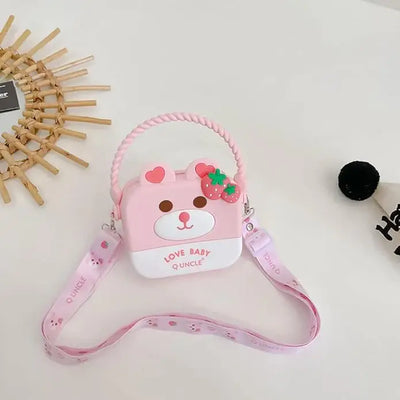 "Front view of a Usmile Toys girls' crossbody purse, made of purple silicone in a charming bunny shape, displayed among tropical leaves." www.usmile.toys