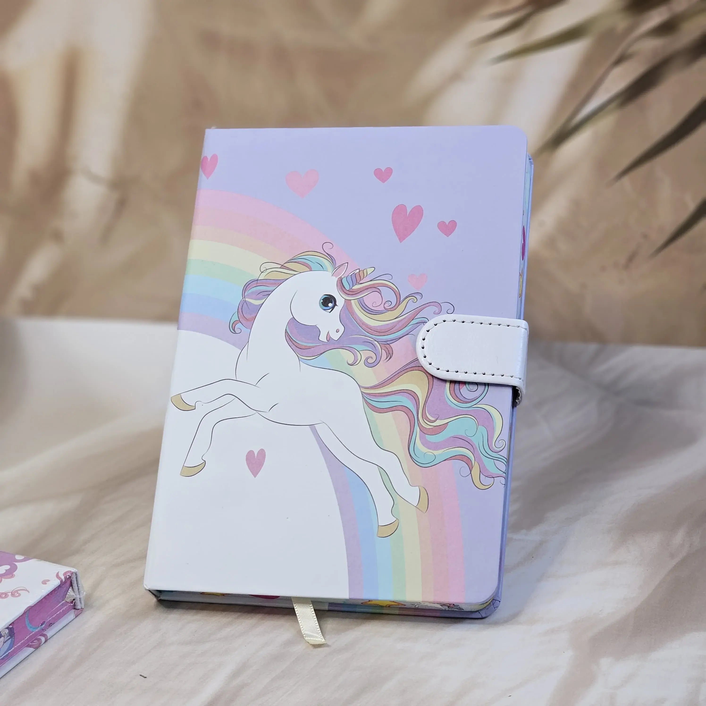Four colorful pocket-sized diaries with unicorn illustrations, including a light blue diary that reads 'TIME TO BE A UNICORN', each with a clasp lock www.usmile.toys