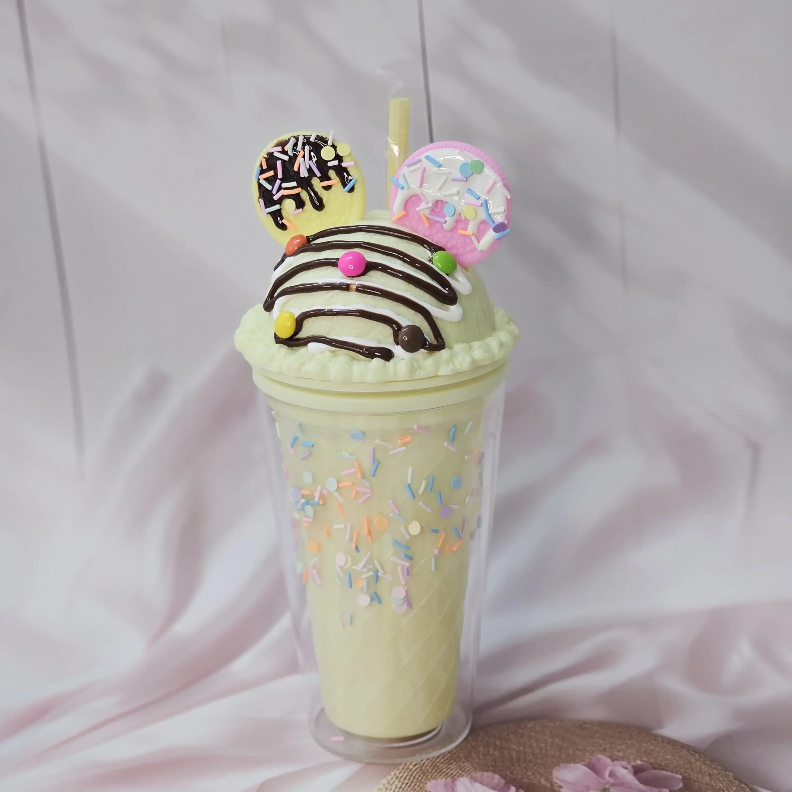 Fun Usmile Toys 'Oreo ice cream' themed tumblers for kids, featuring a pink tumbler with mint green 'frosting' and sprinkles, and a lime green tumbler with chocolate drizzle. These unique sipper cups are ideal for parties and making drinks exciting." www.usmile.toys