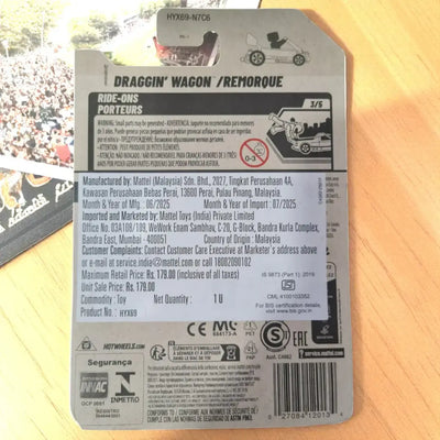 Back of a toy packaging with branding and product details on a wooden surface